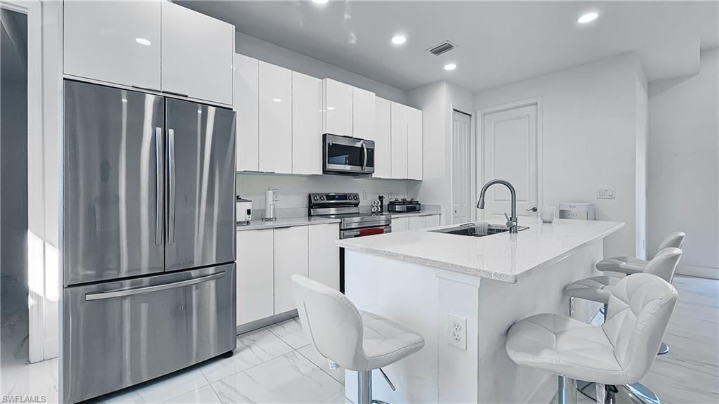 a kitchen with stainless steel appliances a refrigerator sink and microwave