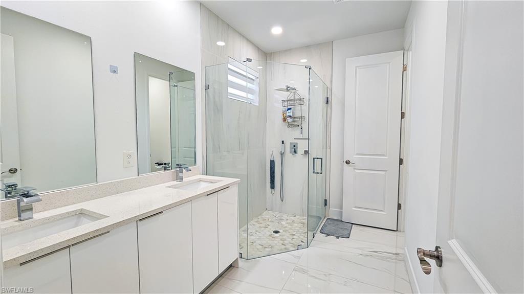 1503 West 17th Street Lehigh Acres, FL 33972 - Photo 11 of 26 a bathroom with a double vanity sink mirror and shower