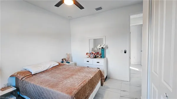 a bed room with a bed and a chandelier fan