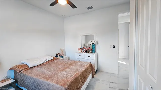 a bed room with a bed and a chandelier fan