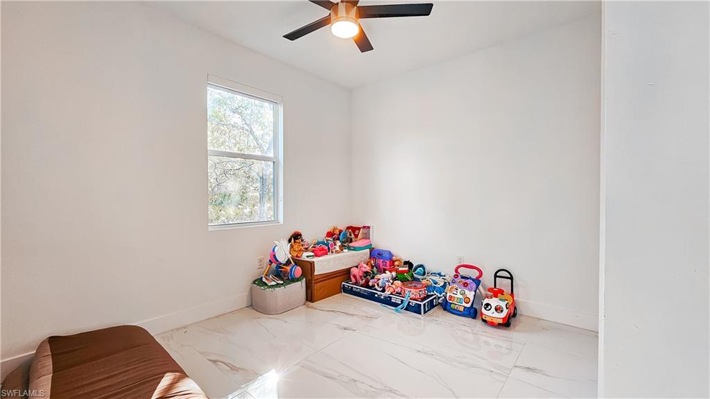 1503 West 17th Street Lehigh Acres, FL 33972 - Photo 20 of 26 a view of a room with toys and a chandelier