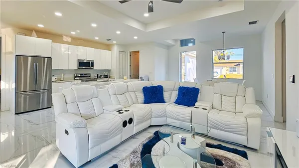 a living room with stainless steel appliances furniture and a window
