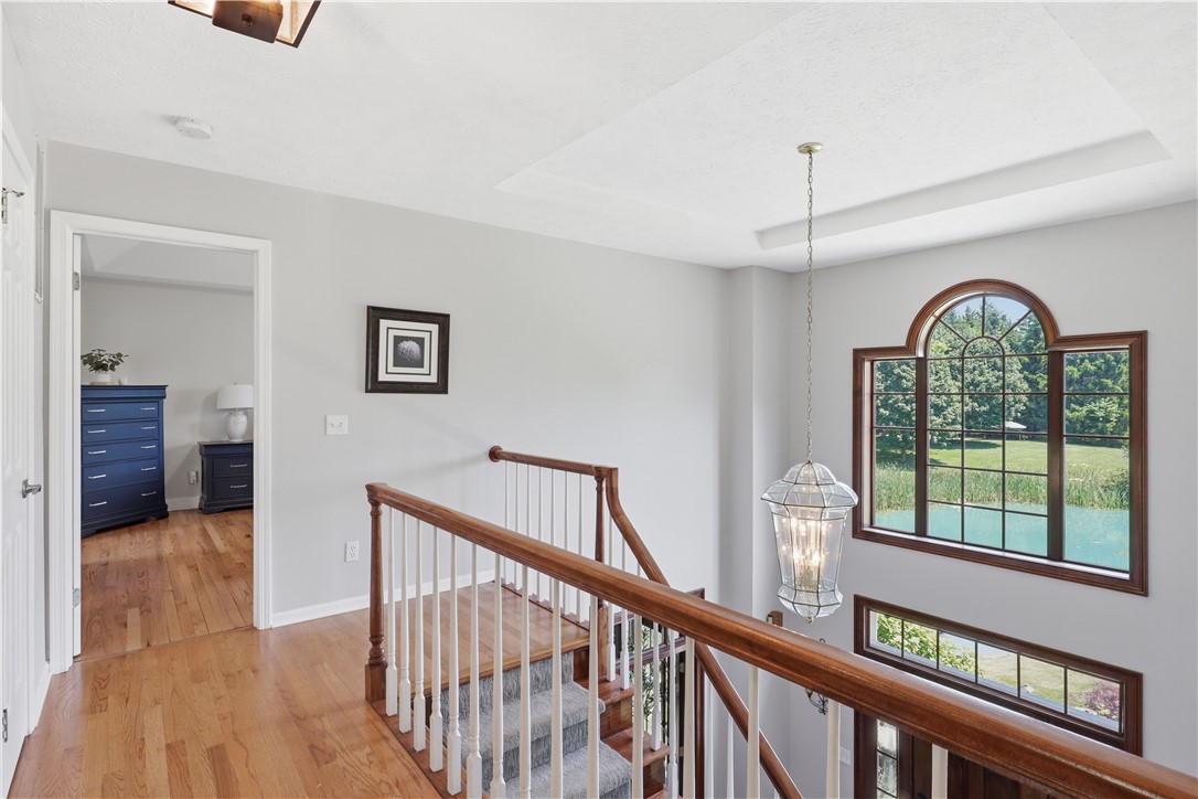 2057 Stirnie Road Victor, NY 14564 - Photo 22 of 48 Ascend to the bright second-floor landing corridor. Illuminated by a large architectural skylight above, this welcoming area offers a warm connection point to the home's upper bedrooms.