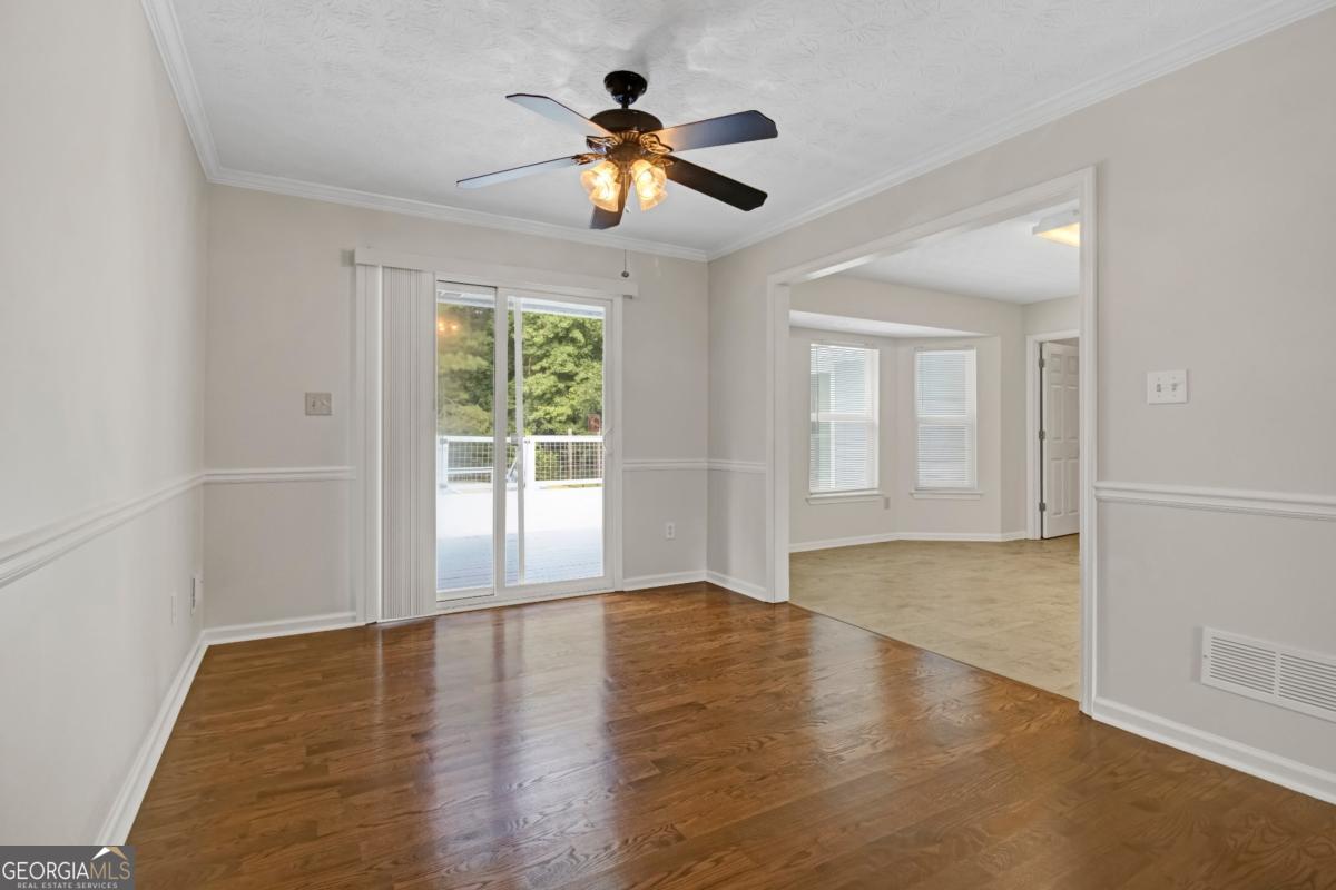 145 Deer Ridge Court McDonough, GA 30252 - Photo 11 of 54 a view of empty room with wooden floor and fan