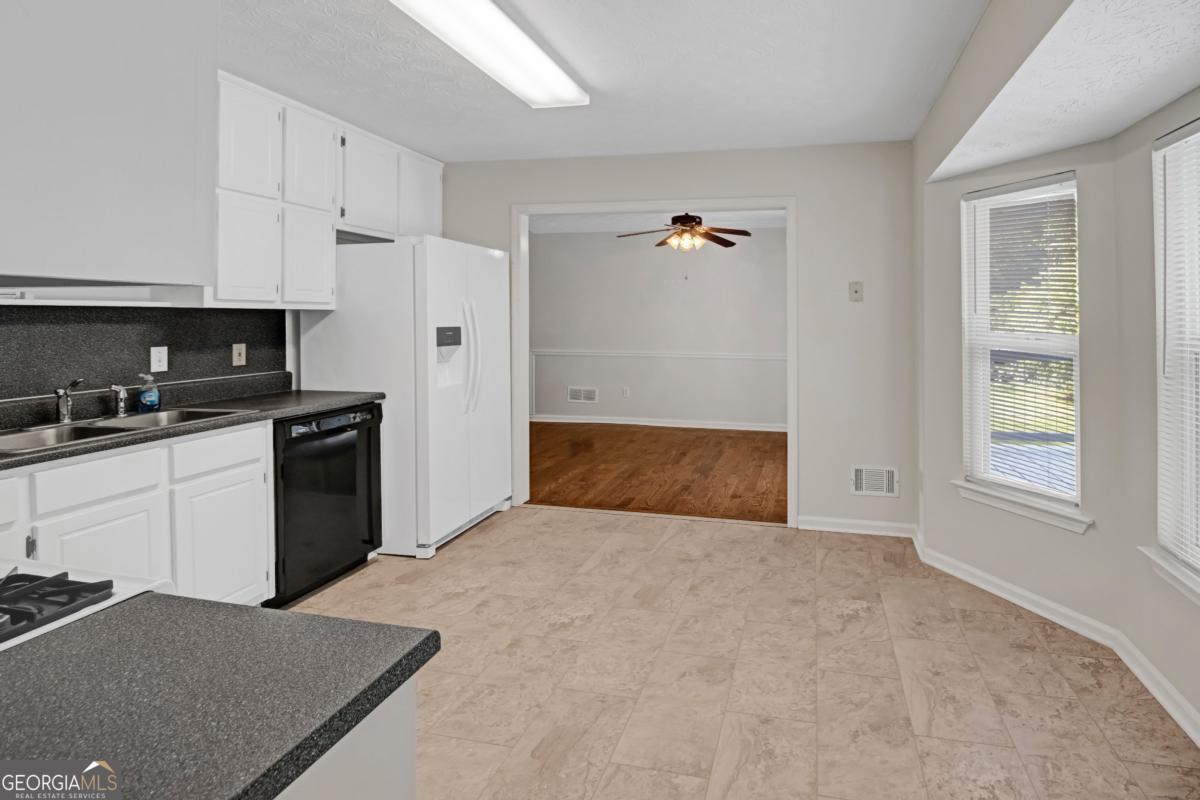 145 Deer Ridge Court McDonough, GA 30252 - Photo 16 of 54 a kitchen with white cabinets and black appliances