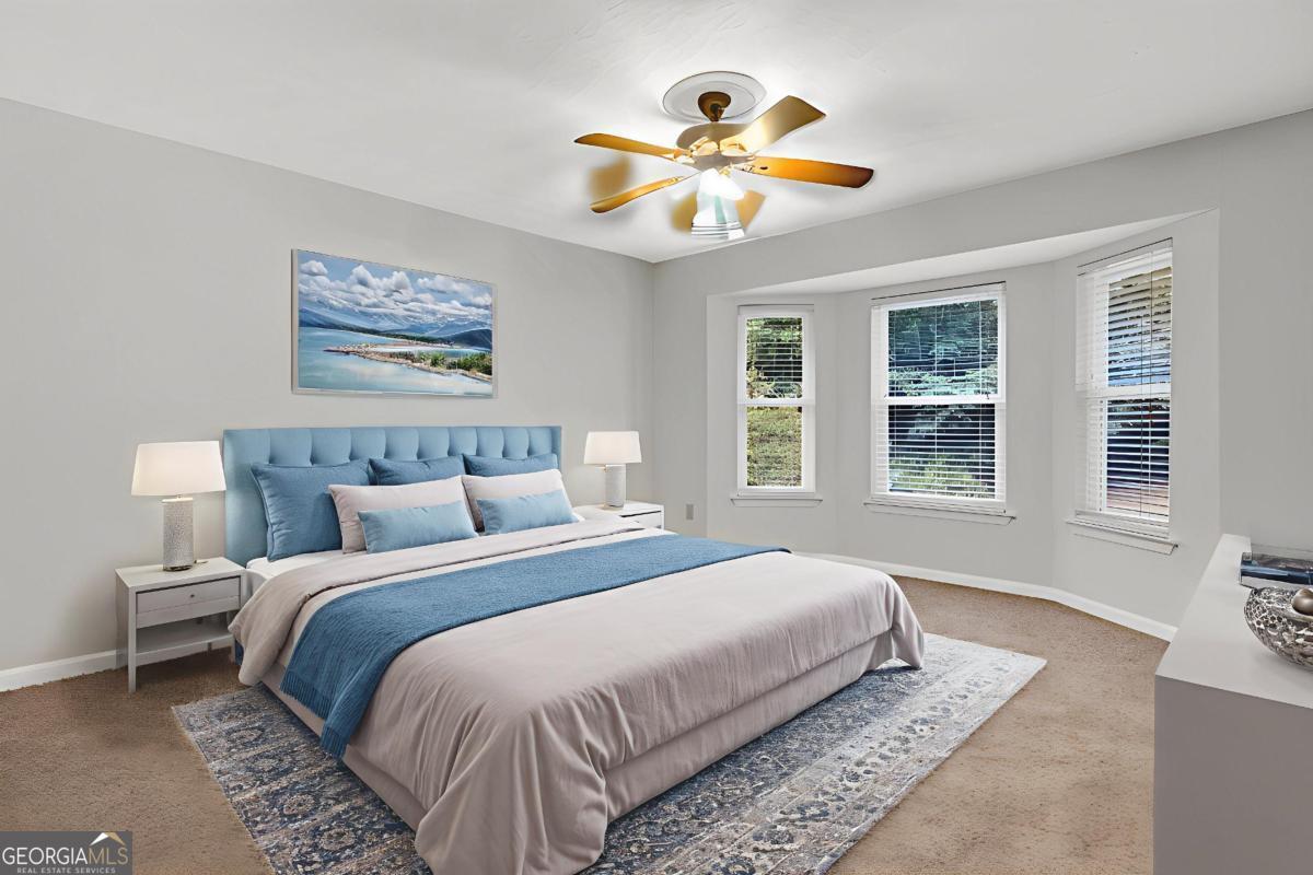 145 Deer Ridge Court McDonough, GA 30252 - Photo 18 of 54 a bedroom with a large bed and a chandelier
