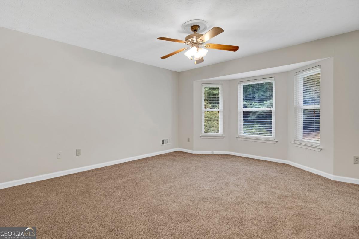 145 Deer Ridge Court McDonough, GA 30252 - Photo 19 of 54 a view of an empty room with chandelier fan and window