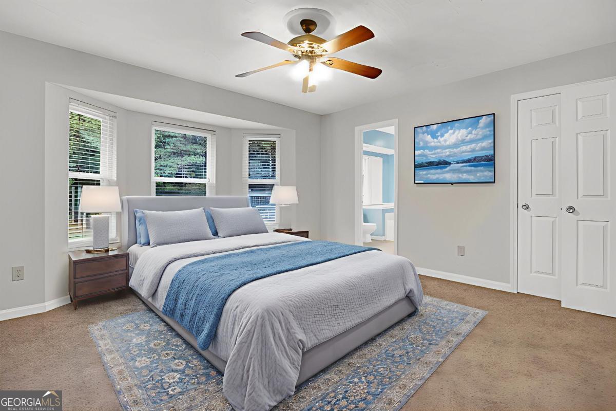 145 Deer Ridge Court McDonough, GA 30252 - Photo 20 of 54 a bedroom with a bed and a chandelier