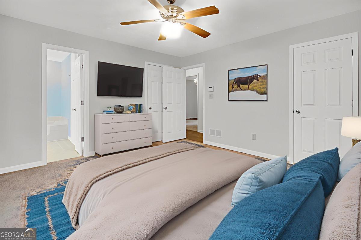 145 Deer Ridge Court McDonough, GA 30252 - Photo 22 of 54 a bedroom with a bed and a flat screen tv