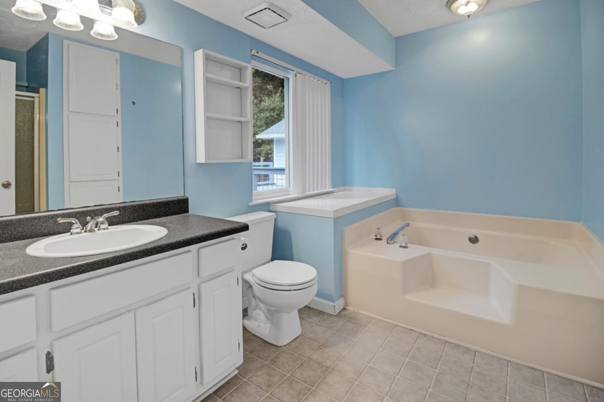 145 Deer Ridge Court McDonough, GA 30252 - Photo 24 of 54 a bathroom with a sink a toilet and a mirror