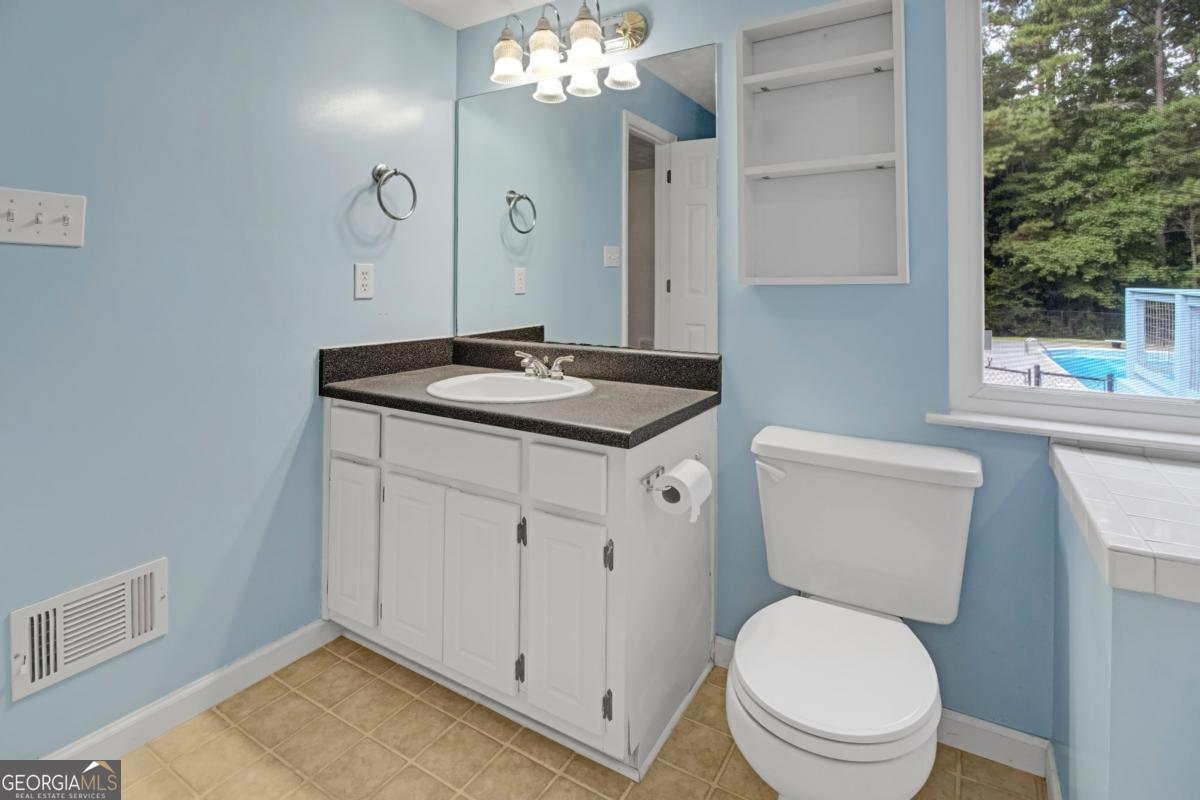145 Deer Ridge Court McDonough, GA 30252 - Photo 25 of 54 a bathroom with a toilet a sink and a mirror