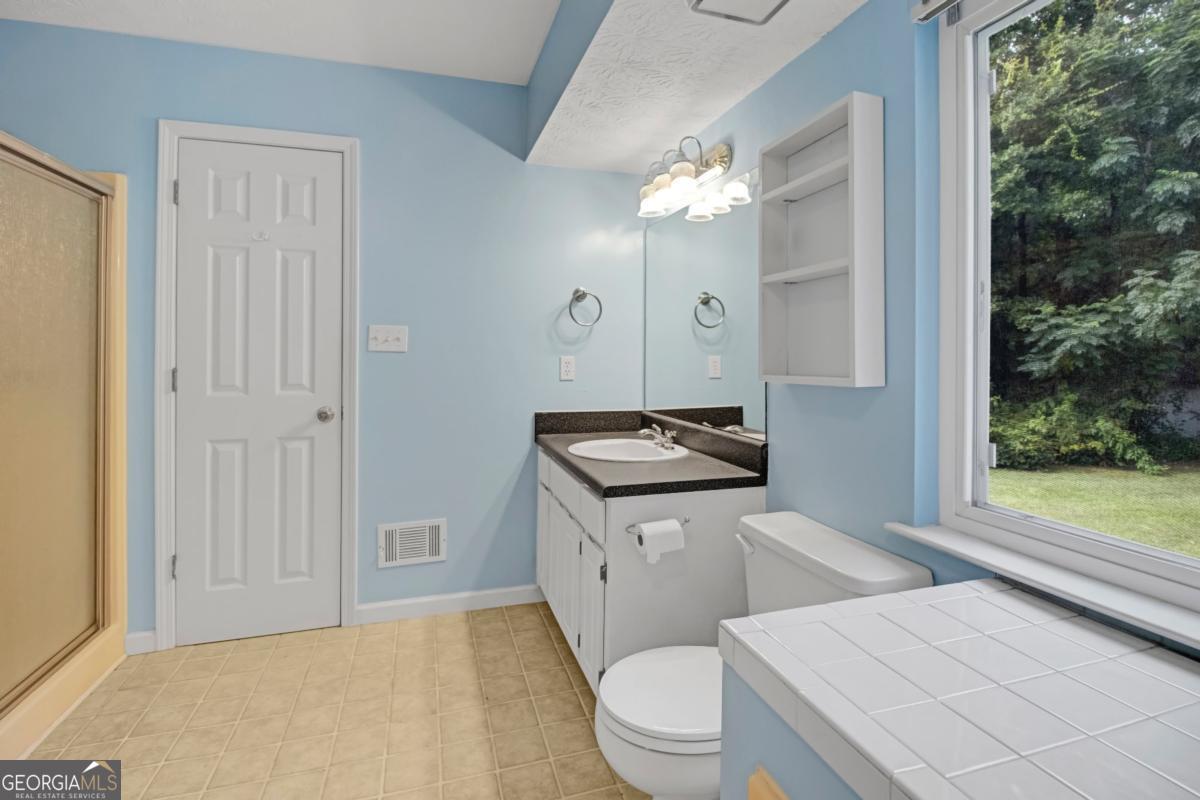 145 Deer Ridge Court McDonough, GA 30252 - Photo 26 of 54 a spacious bathroom with a granite countertop sink a toilet and a shower