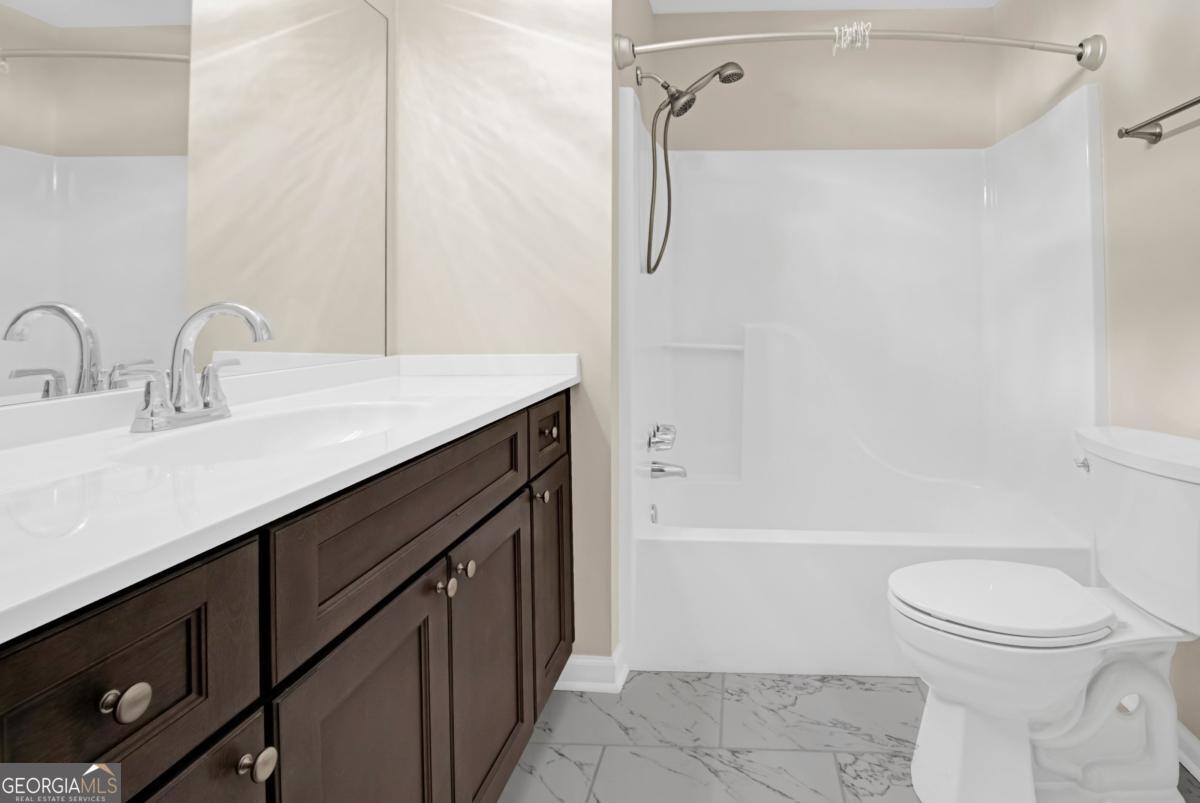 145 Deer Ridge Court McDonough, GA 30252 - Photo 30 of 54 a bathroom with a sink a toilet and shower