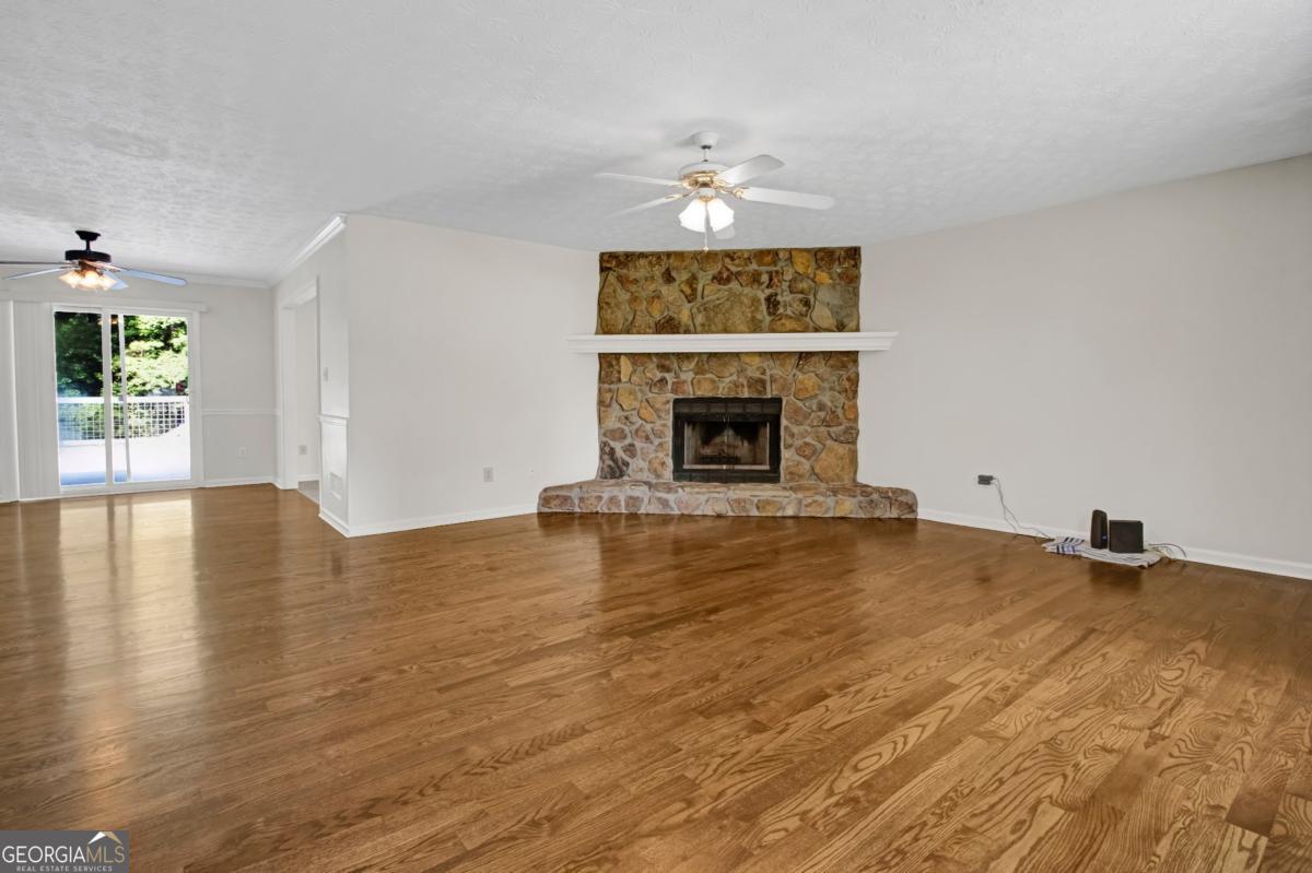 145 Deer Ridge Court McDonough, GA 30252 - Photo 6 of 54 a view of an empty room with wooden floor fireplace and a window