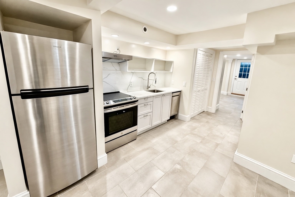 35 Foster Street, Unit A Boston, MA 02135 - Photo 3 of 16 a kitchen with stainless steel appliances a refrigerator sink and cabinets