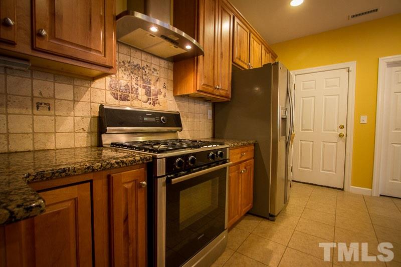 8027 Satillo Lane Raleigh, NC 27616 - Photo 4 of 25 Upgraded kitchen with tile backsplash, granite, and upgraded SS appliances!