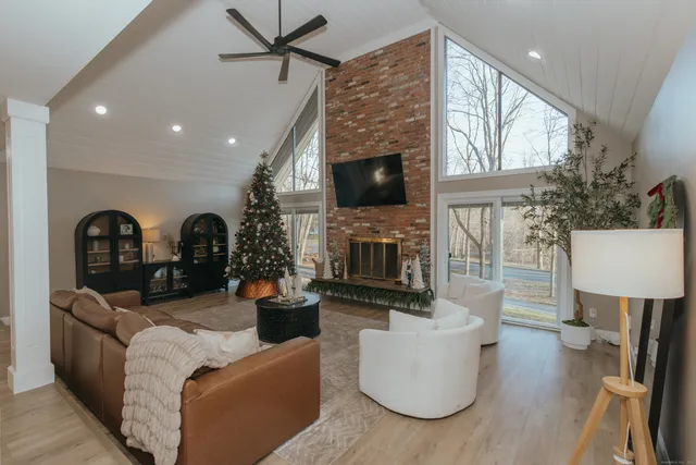 a living room with furniture a fireplace and a flat screen tv