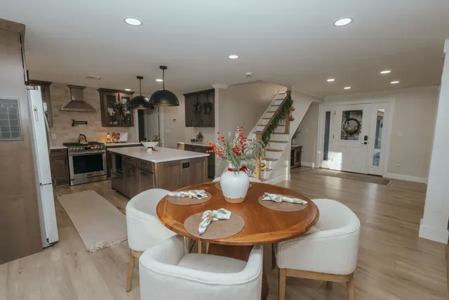 a kitchen with stainless steel appliances kitchen island granite countertop a sink a stove a table and chairs