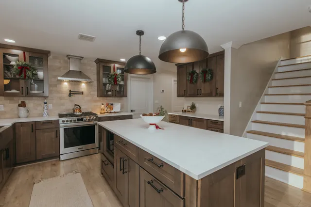 a kitchen with a sink a stove and chairs