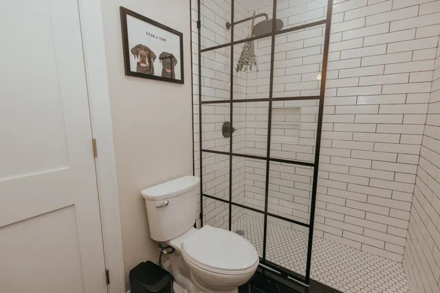 a white toilet sitting next to a shower