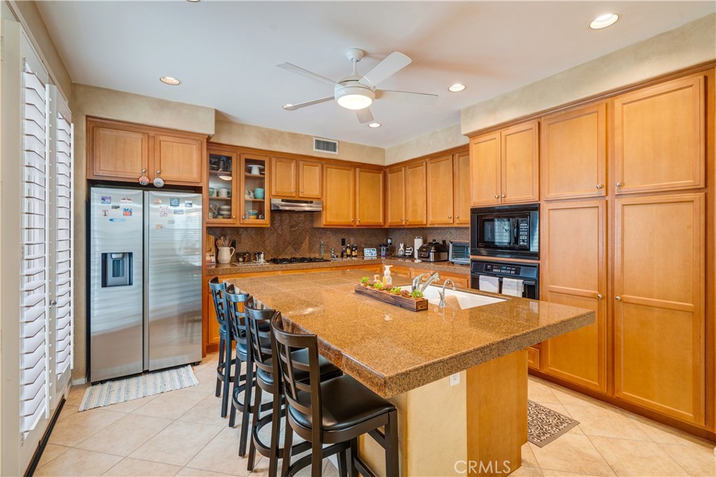 56 Freeland Irvine, CA 92602 - Photo 9 of 28 a kitchen with stainless steel appliances granite countertop a refrigerator a stove a sink a dining table and chairs with wooden floor