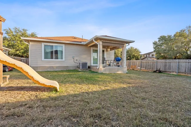 a view of a house with backyard and chairs
