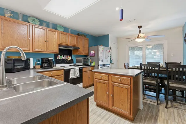 a kitchen with granite countertop a sink a counter top space appliances and cabinets