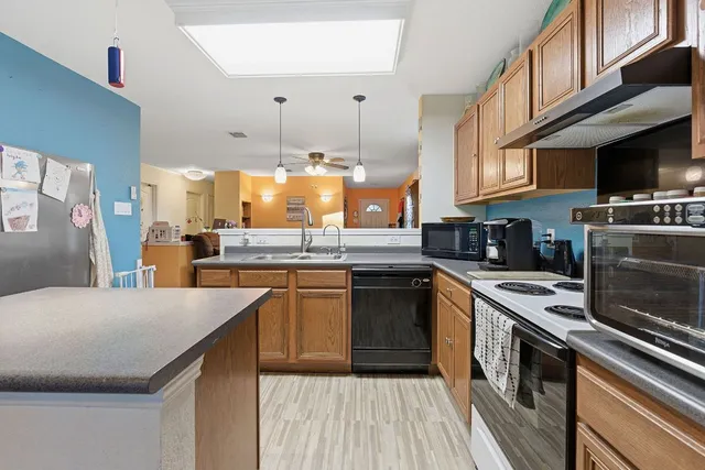 a kitchen with stainless steel appliances granite countertop a stove a sink and a refrigerator