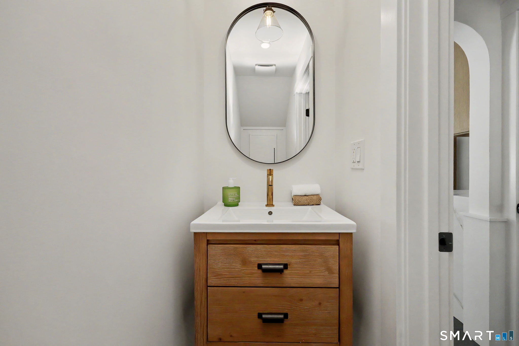 91 Lockwood Road Fairfield, CT 06825 - Photo 18 of 38 a bathroom with a sink a vanity and a mirror