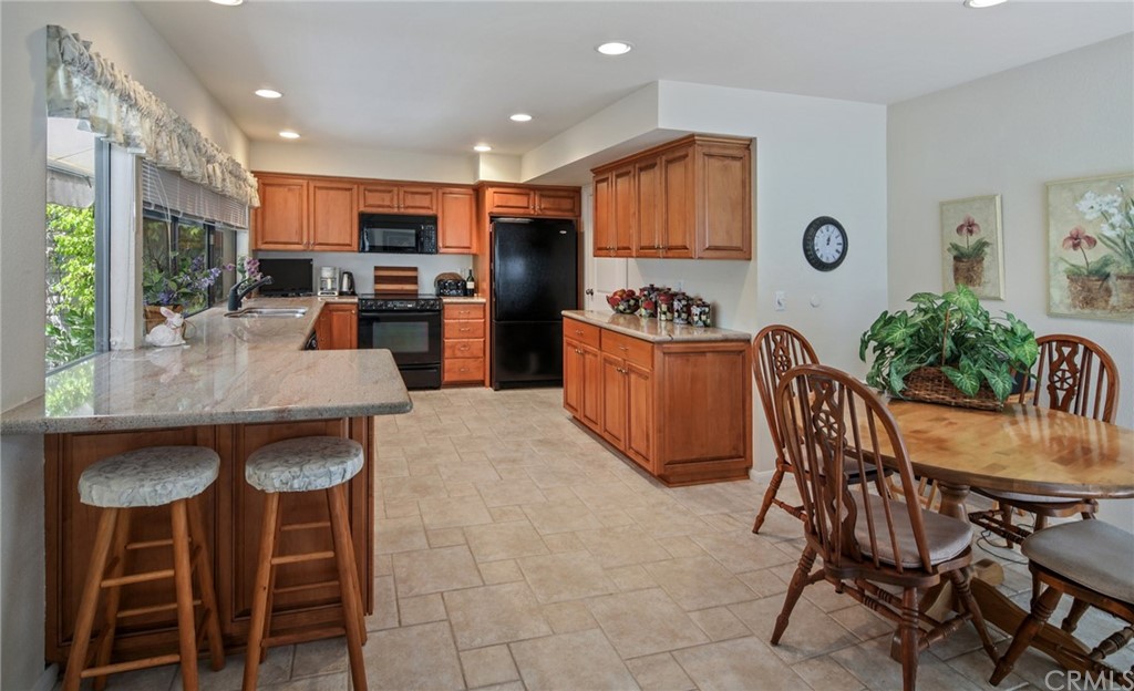 23741 Perth Bay Dana Point, CA 92629 - Photo 6 of 25 a kitchen with granite countertop a table chairs stove and cabinets