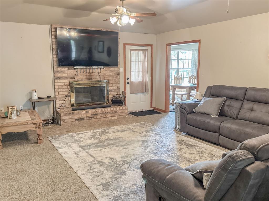 7526 Fm 2114 Road Hubbard, TX 76648 - Photo 11 of 40 a living room with furniture a fireplace and a flat screen tv