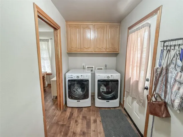 a utility room with wooden floor washer and dryer