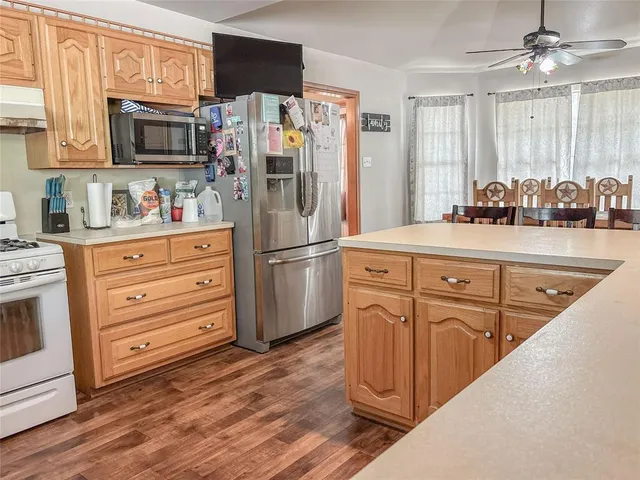 a kitchen with granite countertop a refrigerator stove and sink