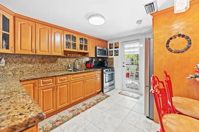 a kitchen with stainless steel appliances granite countertop a stove a sink and a microwave