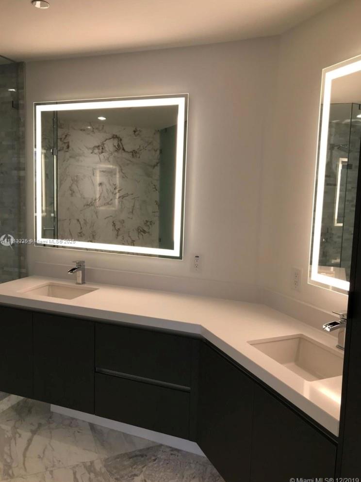 851 Northeast 1st Avenue, Unit 903 Miami, FL 33132 - Photo 9 of 34 a bathroom with a sink and a large mirror