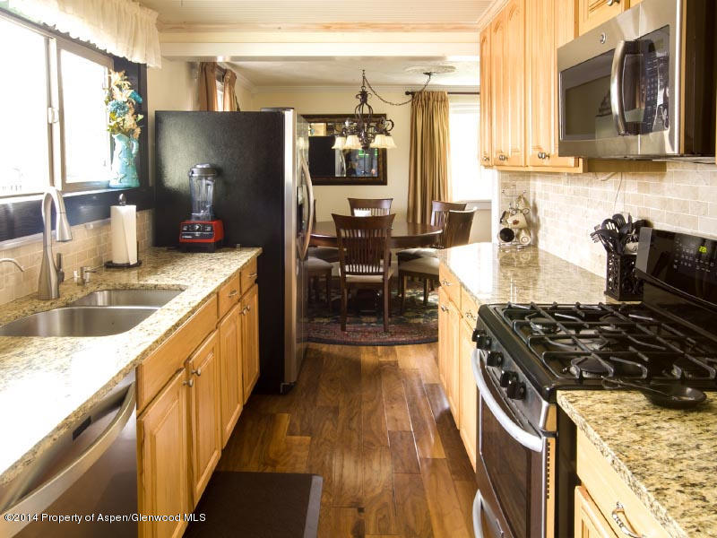 150 Clarkson Avenue Rifle, CO 81650 - Photo 6 of 27 a kitchen with stainless steel appliances granite countertop a sink stove and refrigerator