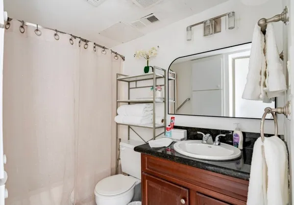 a bathroom with a granite countertop sink and a mirror