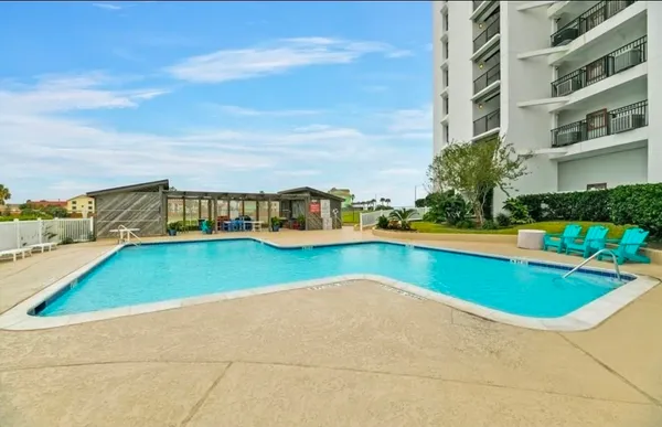 a view of swimming pool with a lawn chairs