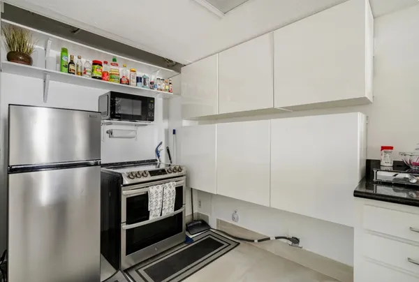a kitchen with a refrigerator and a stove top oven