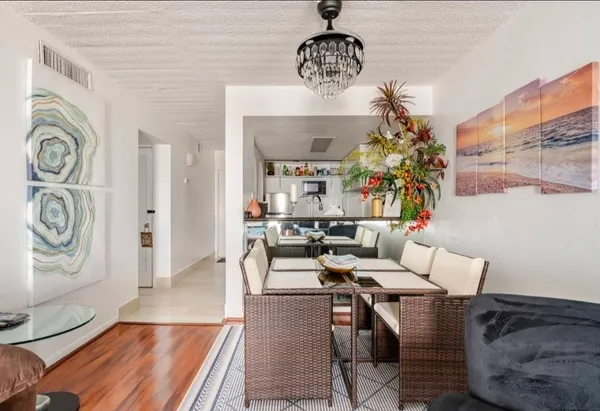 a living room with furniture a chandelier and a rug