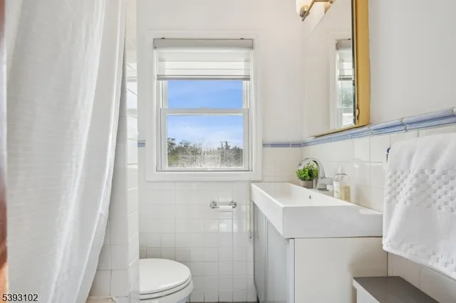 a bathroom with a sink a toilet and a window