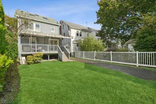 a view of a big house with a big yard and large trees