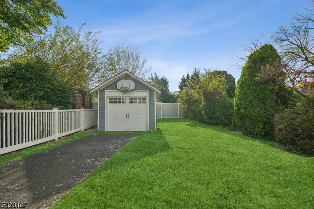 a view of a tiny house with a yard and large trees