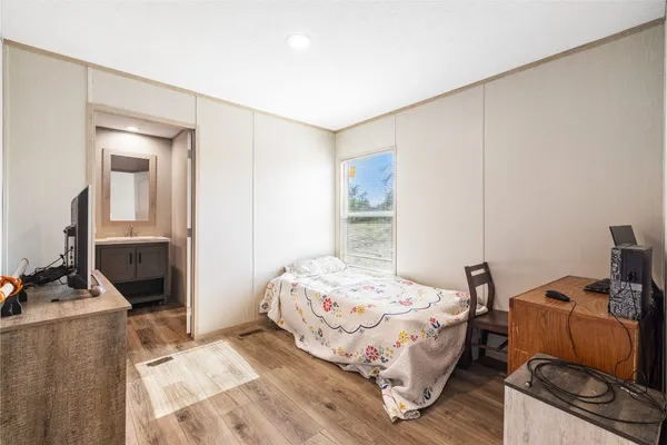 a bedroom with a bed and wooden floor