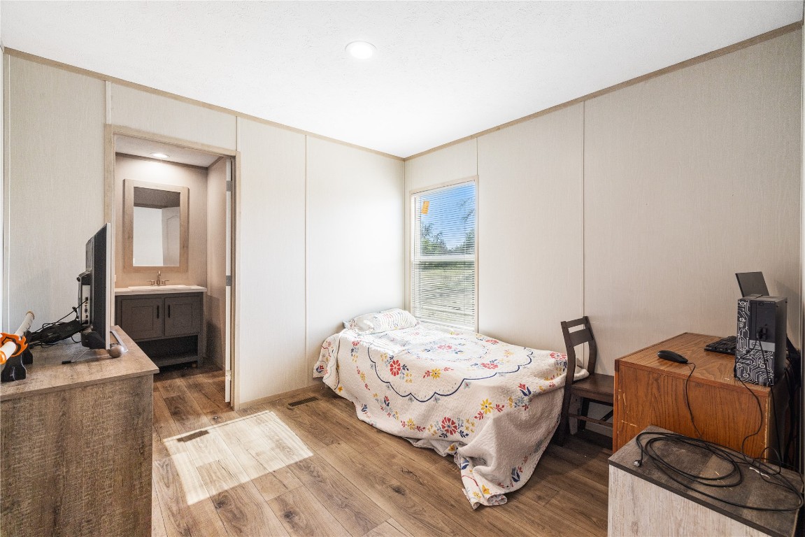 245 Sky Trail Harper, TX 78631 - Photo 13 of 16 a bedroom with a bed and wooden floor