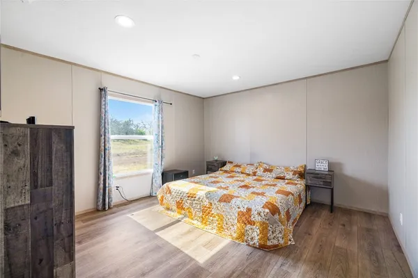 a bedroom with a bed and wooden floor