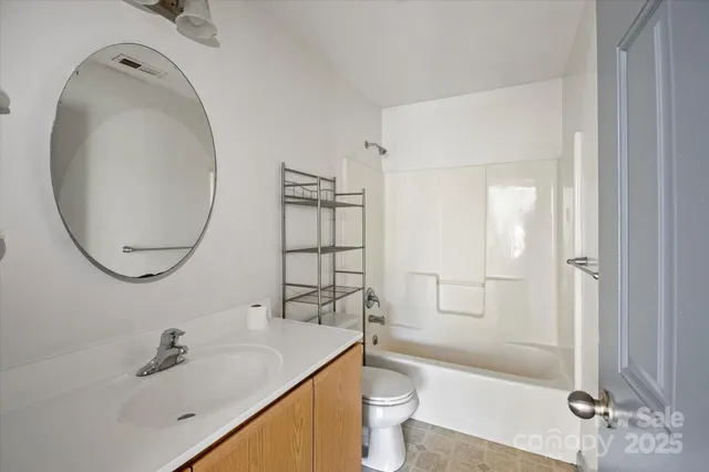 a view of an empty room with wooden floor and closet