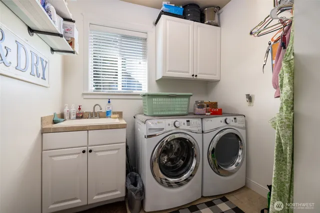 a utility room with cabinets dryer and washer
