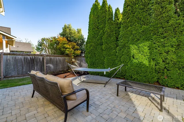 a view of a backyard with couches chair and wooden fence