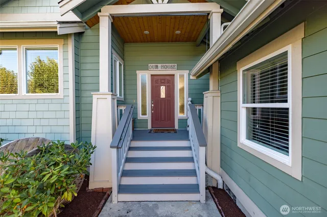a view of a house with large windows and flower plants